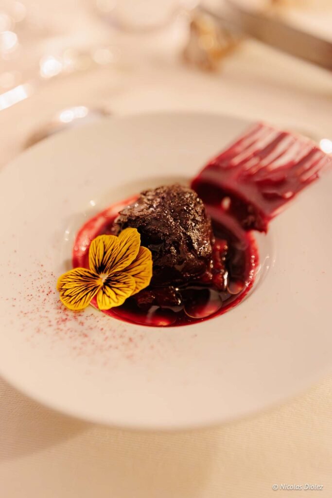 Dessert gastronomique chocolat et fleur comestible au Château de la Rivière.