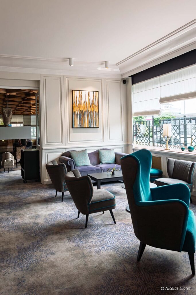 Salon élégant de l'Hôtel d'Angleterre à Châlons-en-Champagne avec canapé confortable et fauteuils design contemporains.