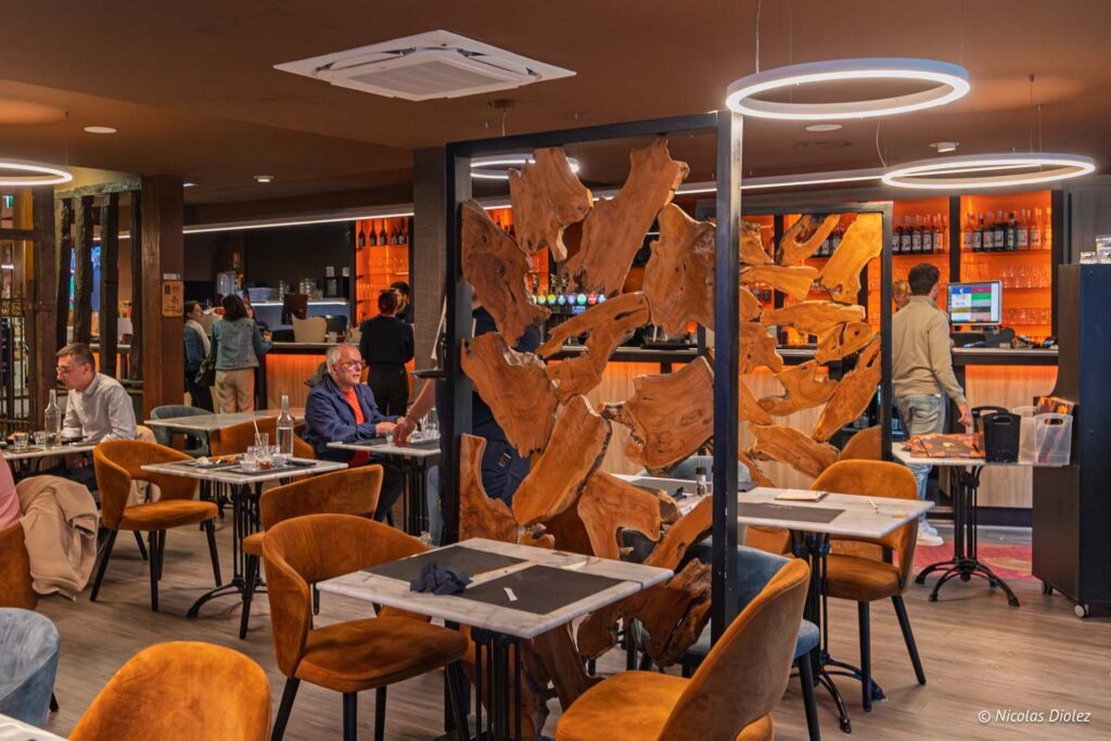 Intérieur du restaurant Le Comptoir de la Licorne à Châlons-en-Champagne avec tables et décoration en bois naturel.