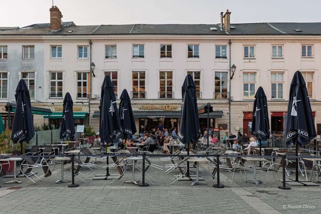 Terrasse du restaurant Le Comptoir de la Licorne avec parasols et clients à Châlons-en-Champagne.