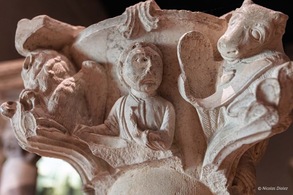Chapiteau sculpté médiéval représentant des figures humaines et animales au Musée du cloître de Châlons-en-Champagne.