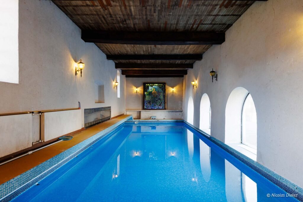 Piscine intérieure chauffée au Château de la Rivière lors d'un séjour romantique.