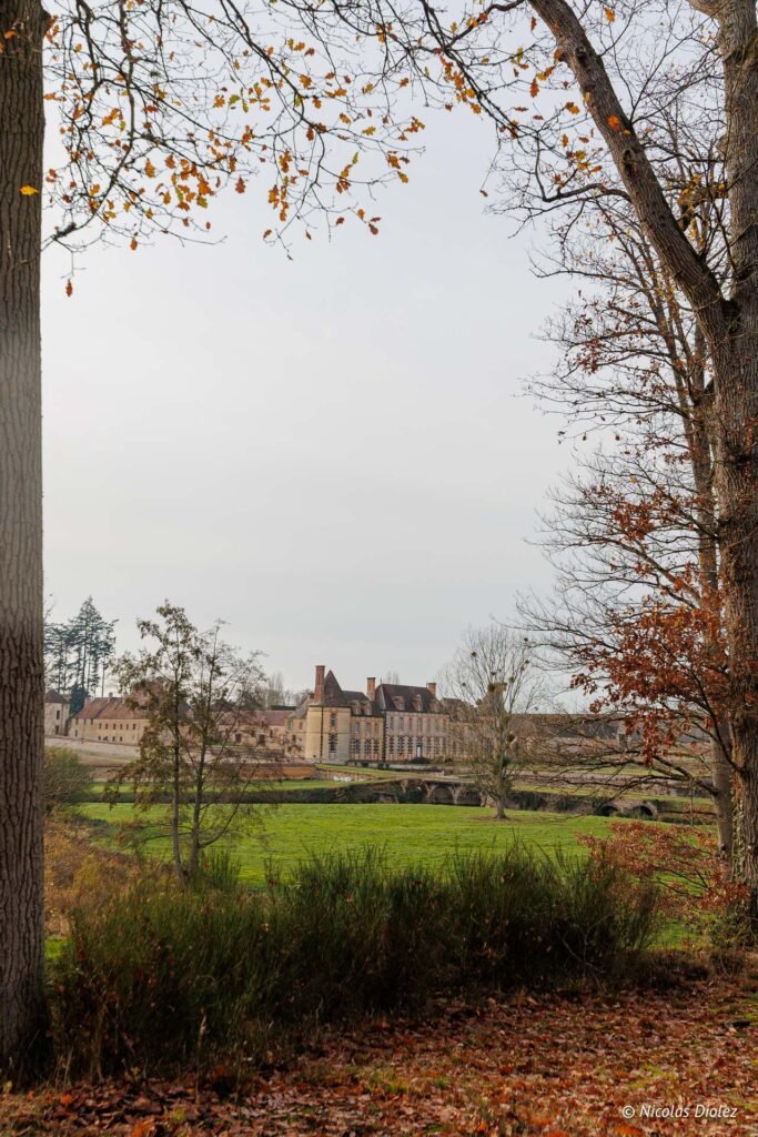 Façade et parc du Château de la Rivière vus à travers les arbres lors d'une escapade romantique.