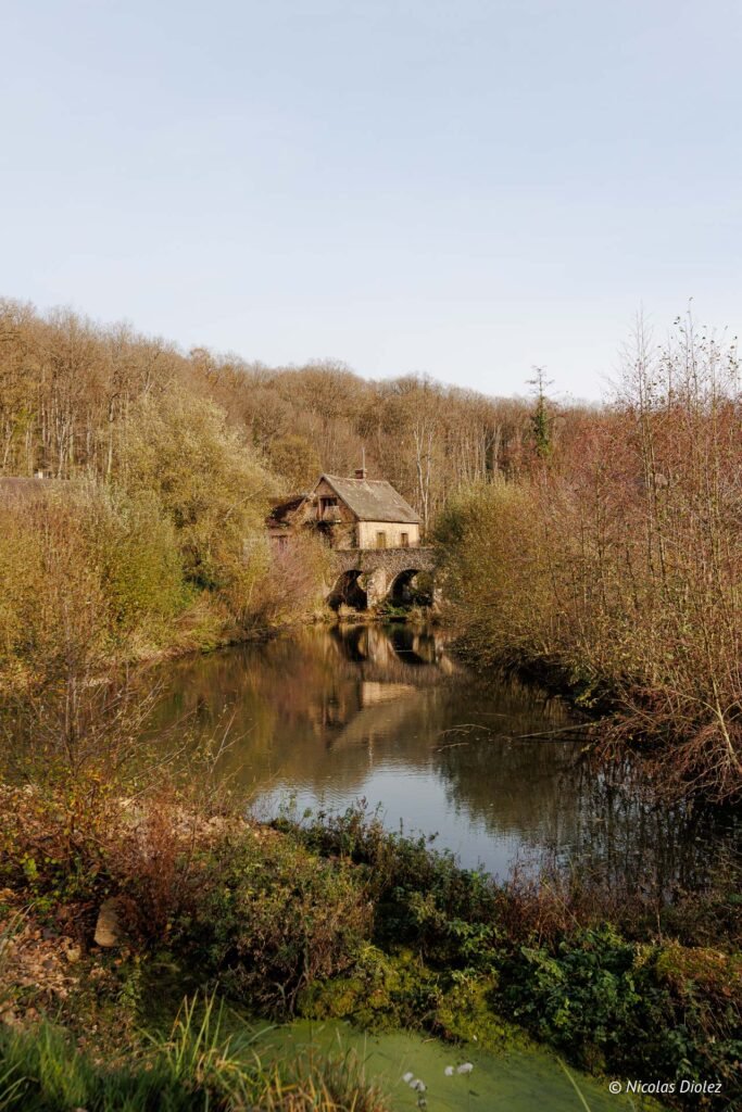 Moulin sur le pont en pierre sur l'étang du Domaine de la Rivière.