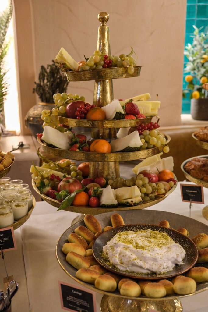 Brunch buffet at Noura restaurant with a fresh fruit display and a plate of labneh with pistachios.