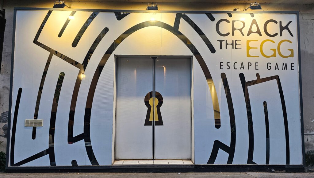 Façade de l'Escape Game Crack the Egg avec une porte centrale ornée d'un motif de serrure.