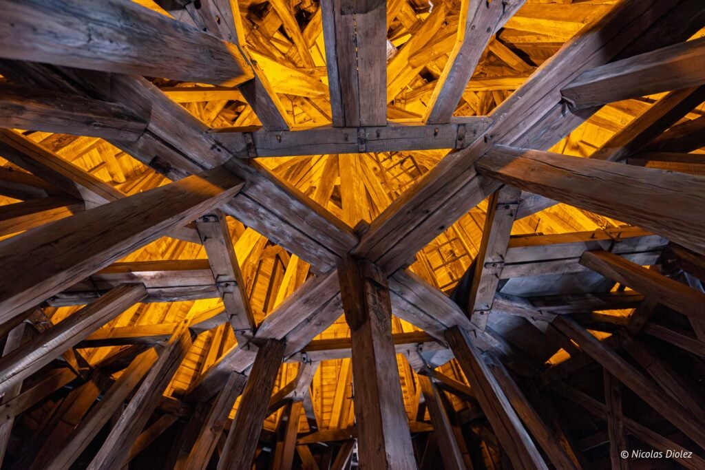 Charpente en bois ancienne illuminée à l'intérieur d'un monument historique de Châlons-en-Champagne.
