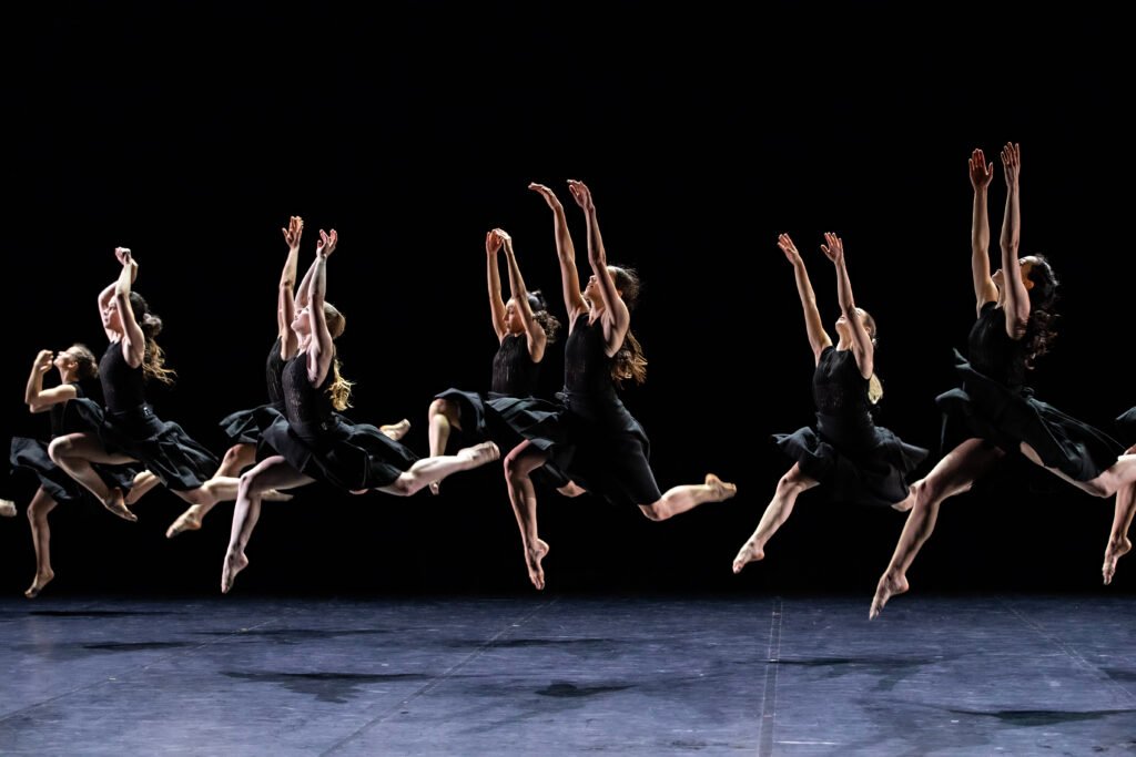 Danseurs exécutant des sauts aériens sur scène lors du spectacle Requiem(s) d'Angelin Preljocaj à Paris.