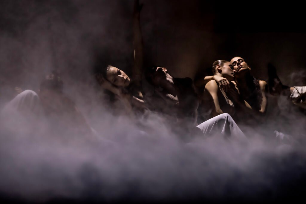 Danseurs sur scène lors du spectacle Requiem(s) d'Angelin Preljocaj entourés de fumée.