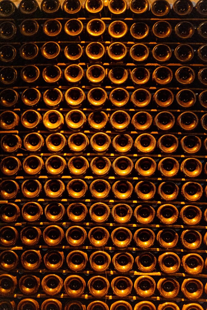 Bouteilles de vin stockées sur des étagères dans une cave à Mâcon pour le vieillissement du champagne.