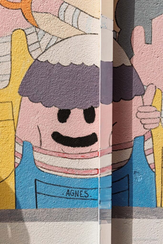 Fresque murale colorée représentant le personnage Agnes dans le quartier de La Pointe Courte à Sète.