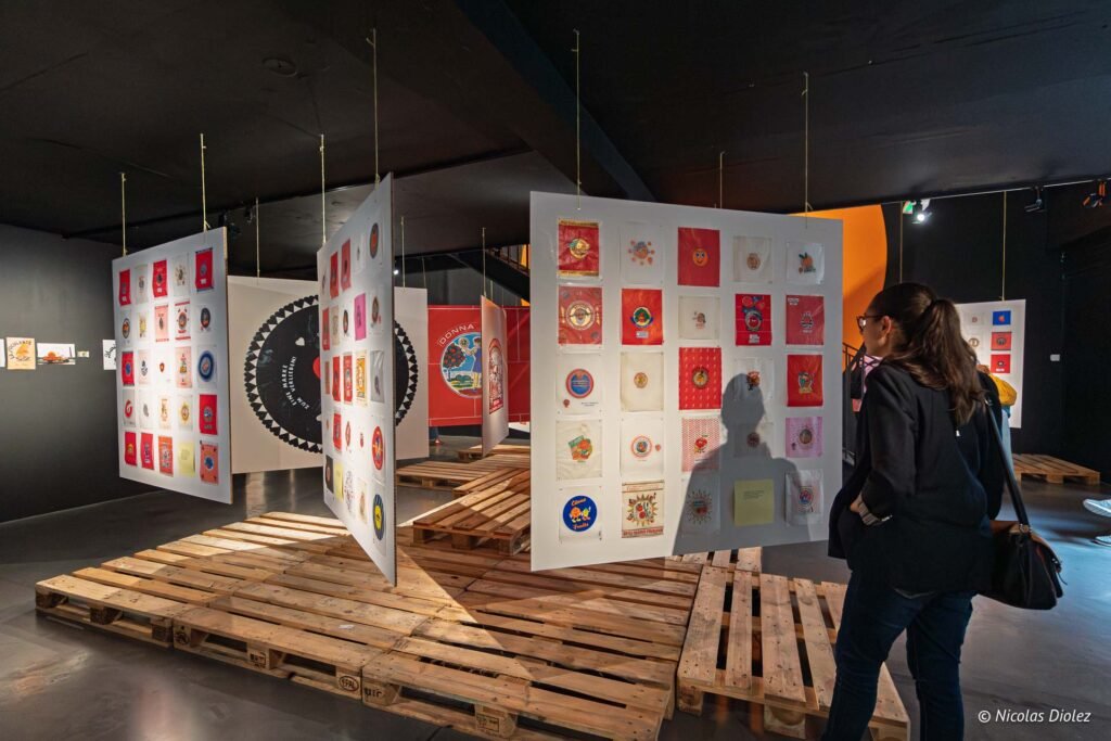 Visiteuse observant des panneaux d'exposition suspendus avec des illustrations graphiques au MIAM de Sète.