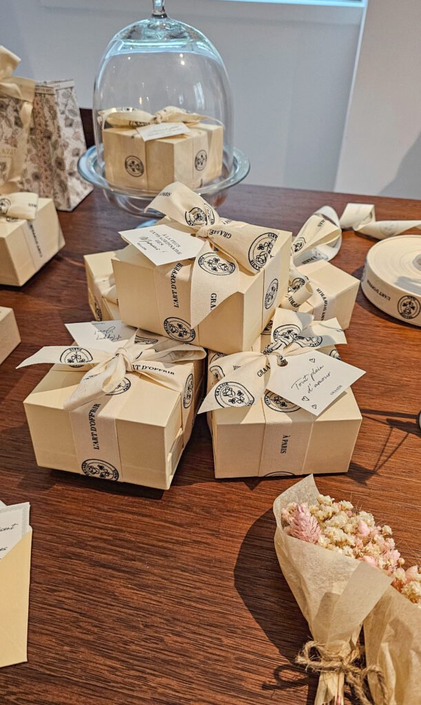Coffrets cadeaux Graazie élégants noués avec des rubans personnalisés, disposés sur une table en bois.