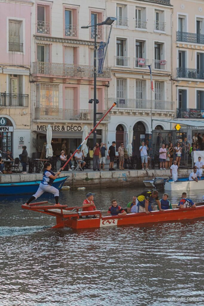 Jouteuse sur une barque lors d'un tournoi traditionnel de joutes nautiques dans le port de Sète.