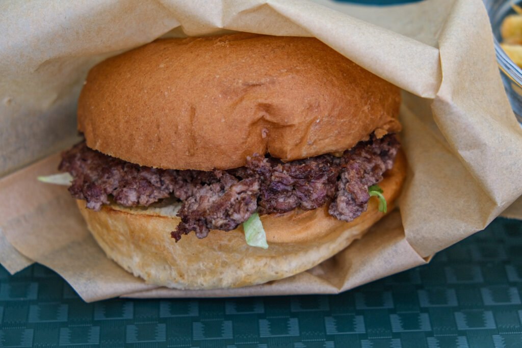 Hamburger juteux servi dans un emballage en papier brun chez Big Sur.