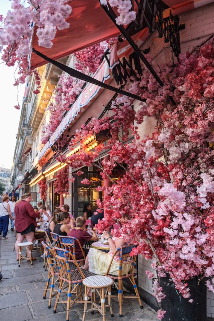Terrasse du restaurant La Favorite à Saint-Paul, décorée de fleurs artificielles, avec des clients attablés en extérieur.