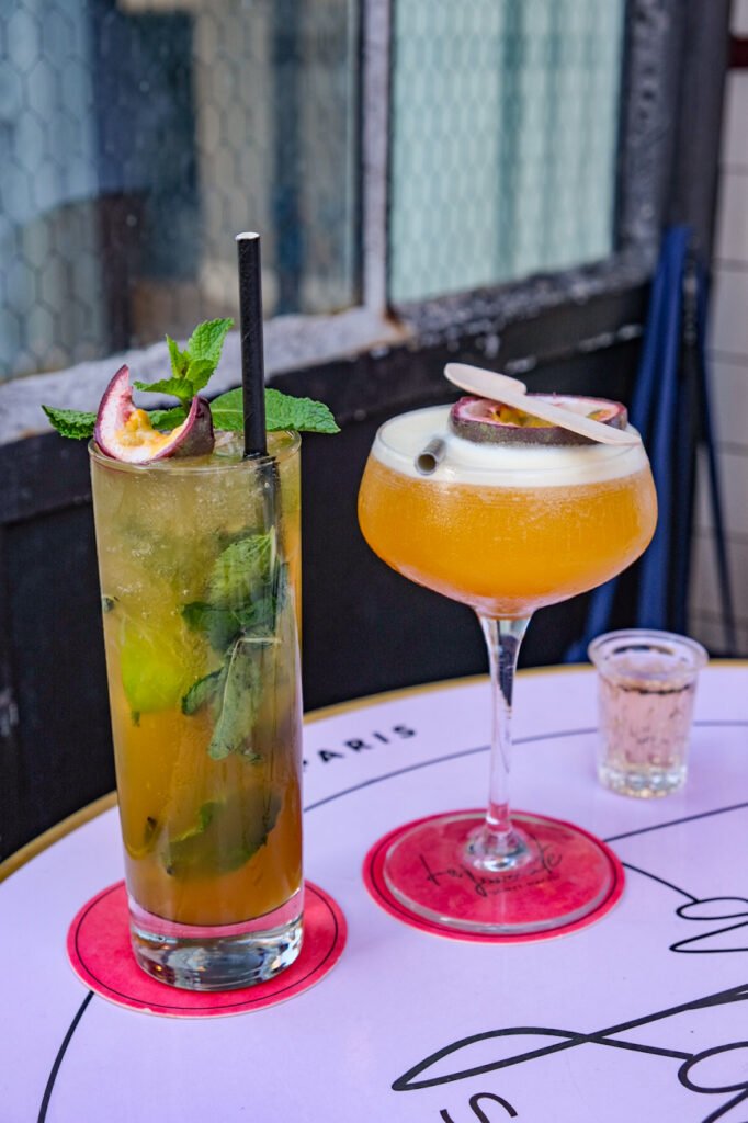 Cocktails aux fruits de la passion et menthe sur une table du restaurant La Favorite Saint-Paul à Paris.