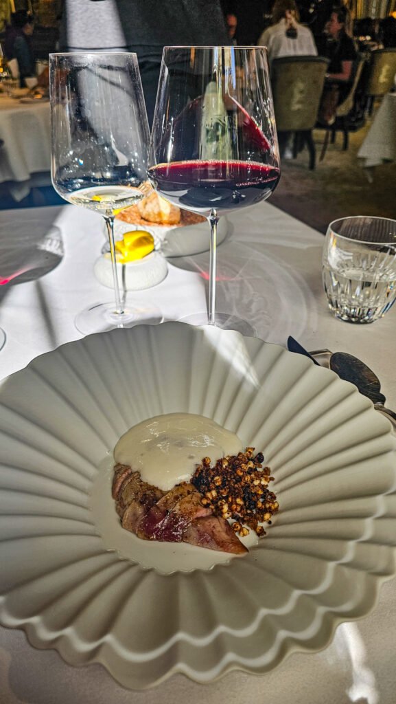 Plat gastronomique au restaurant Le Gabriel servi avec des verres de vin sur une table élégante.