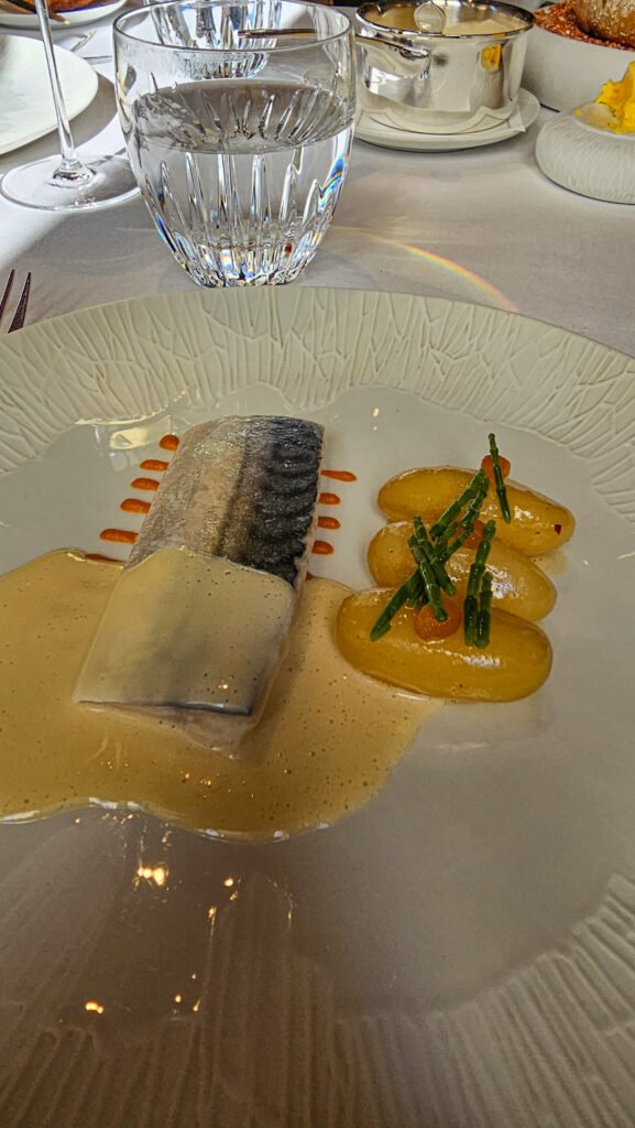 Filet de maquereau gastronomique servi avec des pommes de terre fondantes, de la salicorne et une sauce onctueuse.