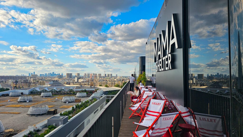 Rooftop panoramique du Mama Shelter Paris West avec chaises longues et vue sur la ville.