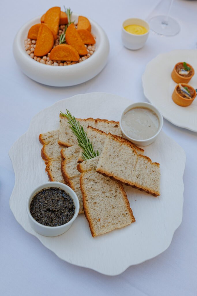 Tranches de pain grillé accompagnées de tapenade et sauce sur la terrasse de l'Hôtel Le Collectionneur.
