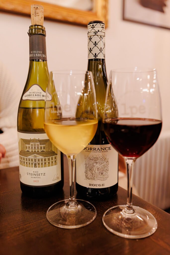 Bottiglie di vino bianco Schloss Gobelsburg e di vino rosso Dorrance con bicchieri a La Petite École, Parigi.