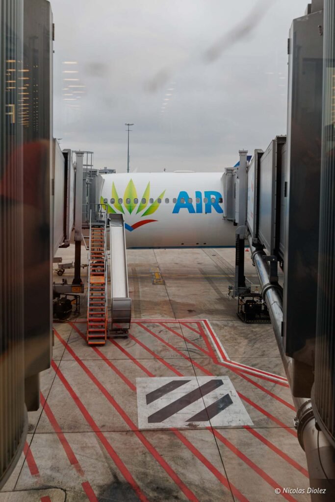 Avion d'Air Caraïbes connecté à une passerelle d'embarquement lors d'un vol inaugural vers Saint-Martin.