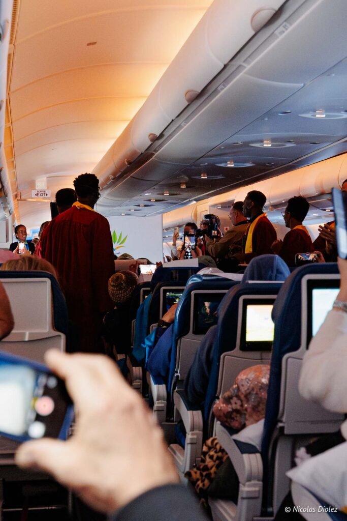 Passagers à bord d'un vol inaugural d'Air Caraïbes vers Saint-Martin, photographiant l'événement depuis les sièges de l'avion.