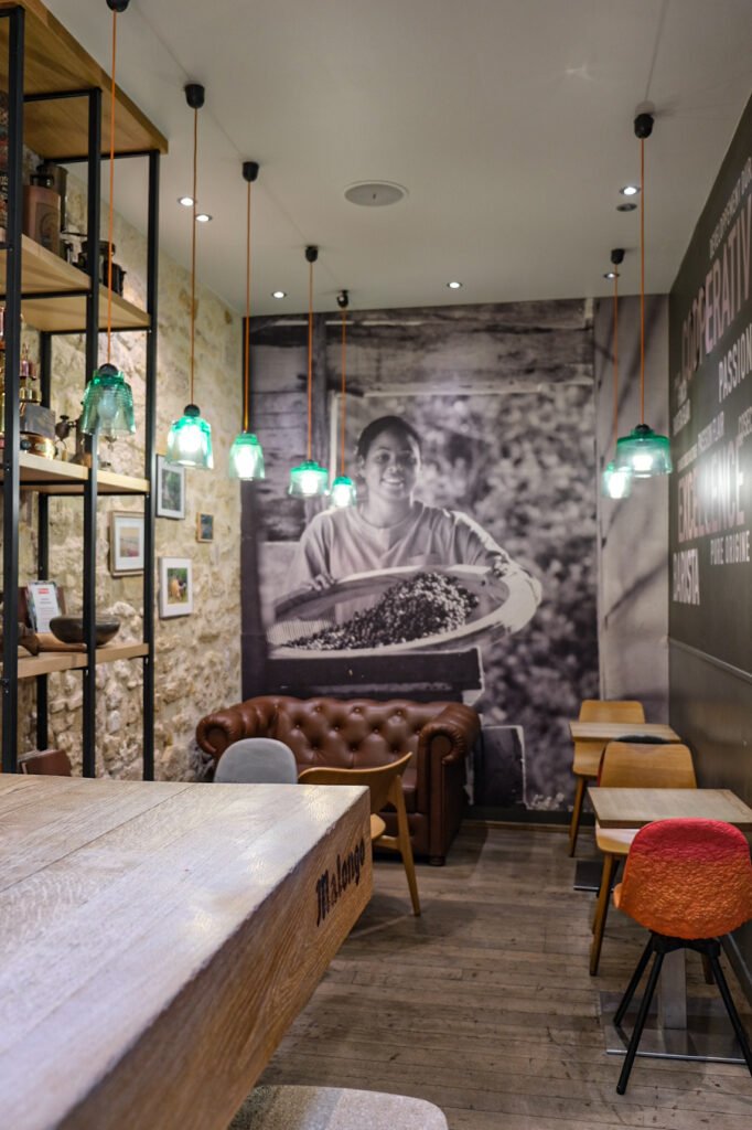 Interior of a Malongo barista workshop with wooden furniture, leather sofa, and wall decoration about coffee.