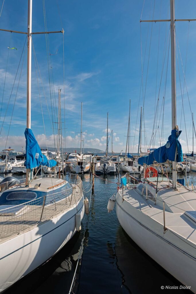 Voiliers amarrés au port de plaisance entre Mèze et Sète sous un ciel ensoleillé.