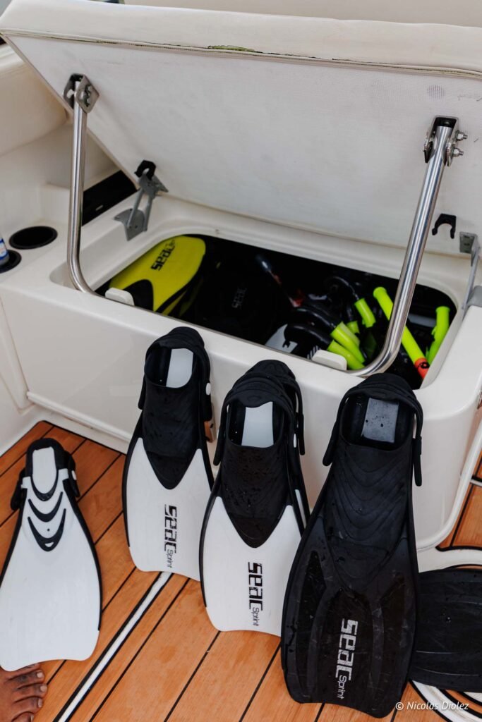 Paires de palmes de plongée Seac posées sur le pont d'un bateau lors d'une excursion à Saint-Martin.
