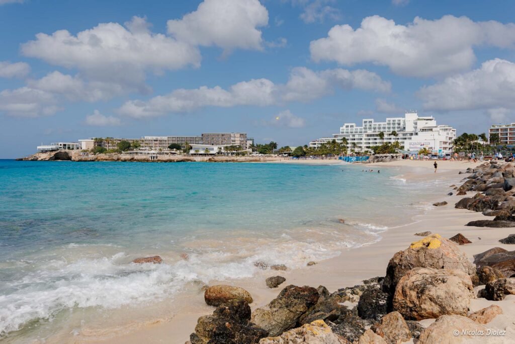 Plage de sable blanc et mer turquoise bordée d'hôtels dans la partie hollandaise de Saint-Martin.