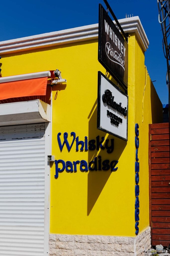 Façade jaune de la boutique Whisky Paradise dans la partie hollandaise de Saint-Martin.