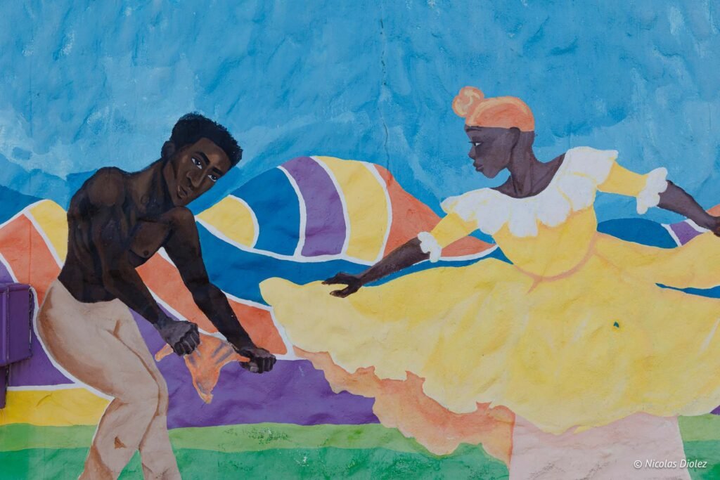 Fresque murale colorée à Saint-Martin représentant un homme et une femme dansant.