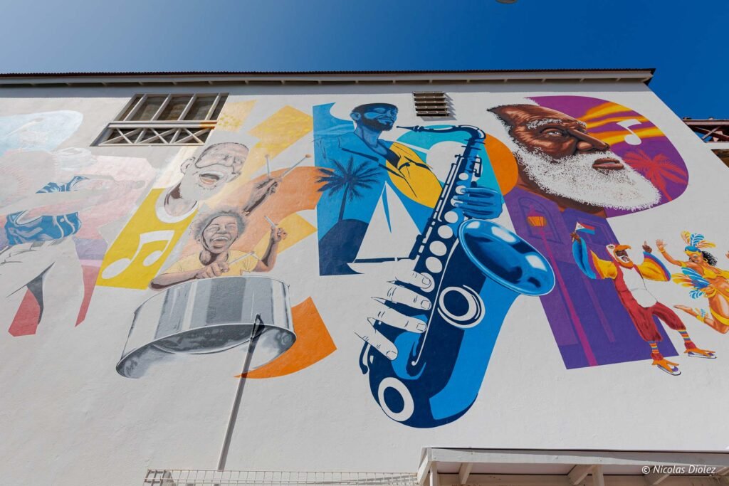 Grande fresque murale colorée représentant des musiciens, un saxophoniste et des danseurs à Saint-Martin.