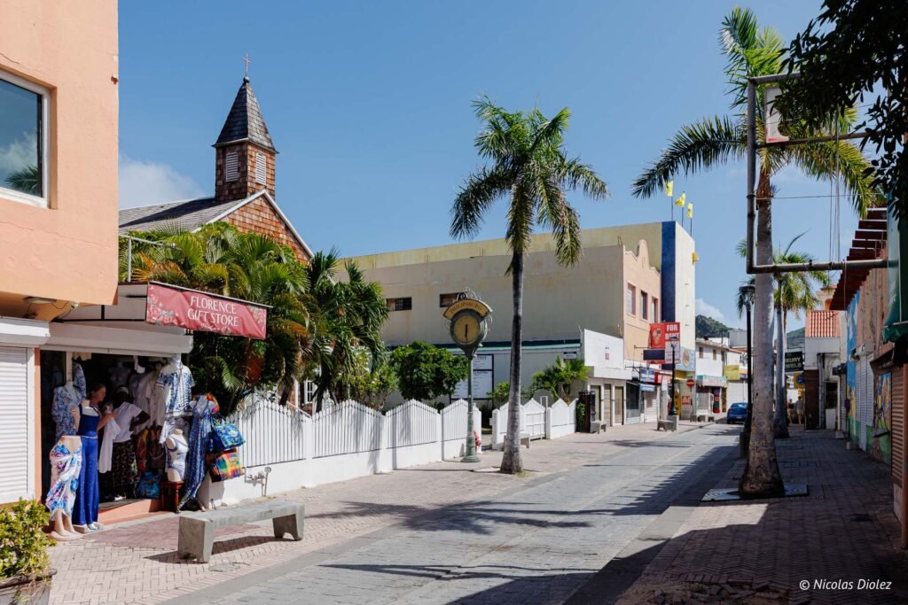 Rue commerçante animée de Philipsburg avec une église, des boutiques et des palmiers dans la partie hollandaise de Saint-Martin.