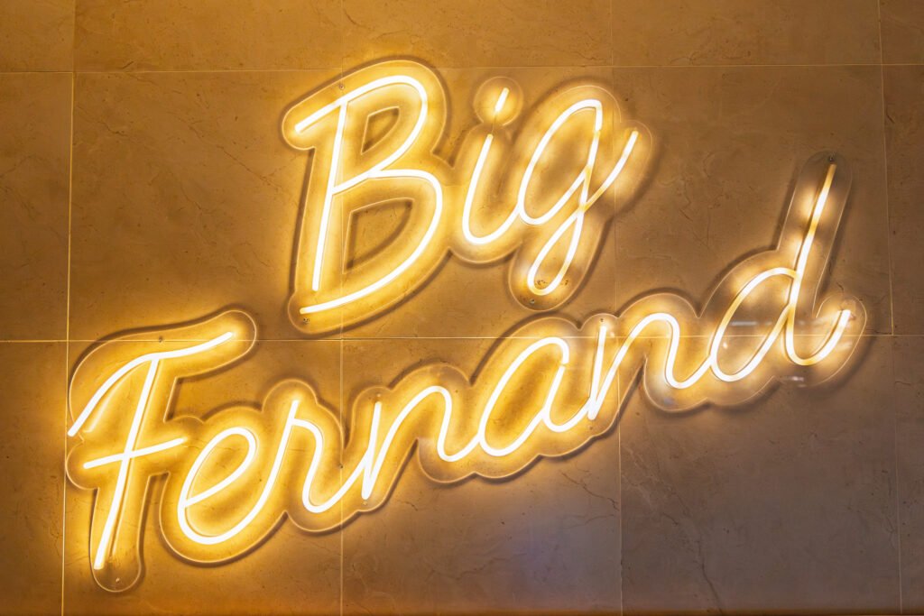 Enseigne lumineuse au néon affichant le logo Big Fernand sur un mur.