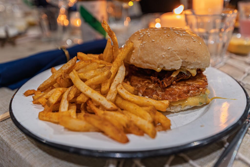 Burger au saumon accompagné de frites servi dans une assiette chez Big Fernand à Paris.