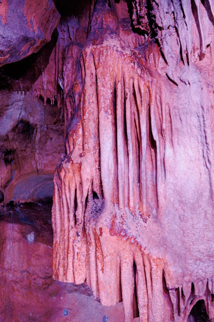 Large stalactites and colorful limestone concretions inside the Saulges caves.
