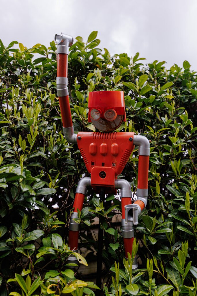 Plastic robot sculpture made from recycled pipes in a garden in Saint-Pierre-sur-Erve.