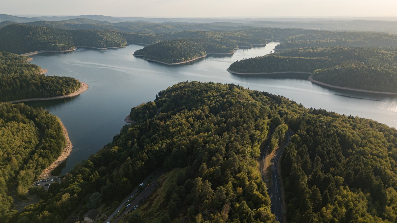 Vue aérienne du lac de Pierre-Percée entre les collines boisées.